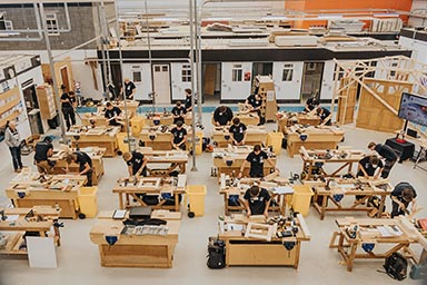 The Merlane Trophy competition in full swing, with students working at individual workbenches.
