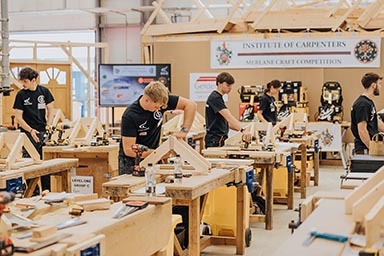 The Merlane Trophy competition in full swing, with students working at individual workbenches.