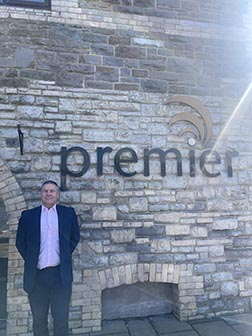 Premier Forest Products group sales director, Andrew Stevenson, in front of a Premier sign.