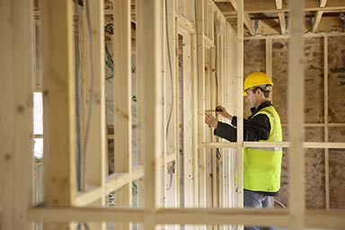 A workman in a timber frame building under construction.