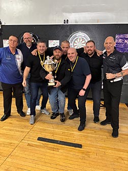 Eight men gathered around a trophy.