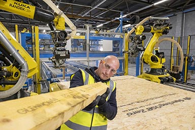 A man working with timber in a factory setting.