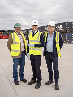 Three men in hard hats and hi-vis jackets.