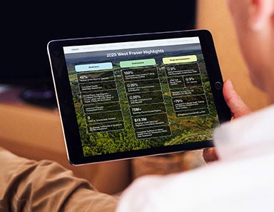 A man studying the West Fraser 2025 Sustainability Report on an iPad.
